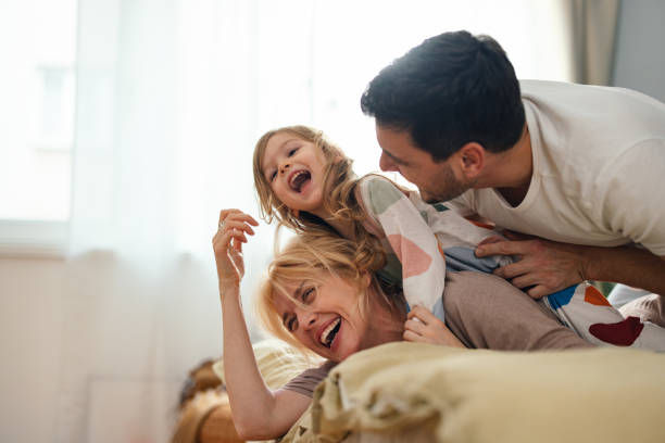 Happy family playing together on a bed