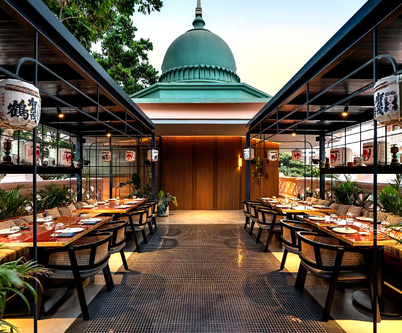 KOKO KOKO is conceptualized as a premium, culinary theatre where the overall atmosphere and spatial hierarchy dictate the flow of the evening. The design moves away from traditional, flat-layout dining rooms, opting instead for a vertical progression that transitions from quiet luxury to a high-energy lounge. On the ground floor, a sunlit, conservatory-inspired entrance connects directly with a lush, plant-lined outdoor garden patio. The first level houses the exclusive, moody KOKO Privé bar and a private sixteen-seat executive suite designed for ultimate isolation. Ascending to the top tier reveals an open-air, panoramic rooftop terrace that acts as a dramatic stage overlooking the Bengaluru skyline.