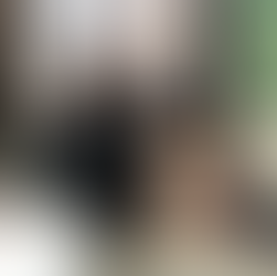 A woman posing in front of windows in the sunlight.