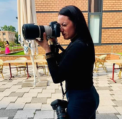 Fotós munka közben, természetes környezetben képet készítő nő.