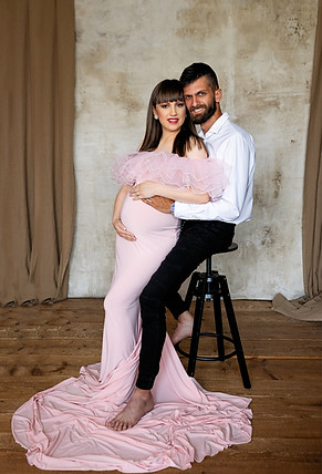 Kismama portré, nő kezét a pocakján tartva, meghitt pillanat.