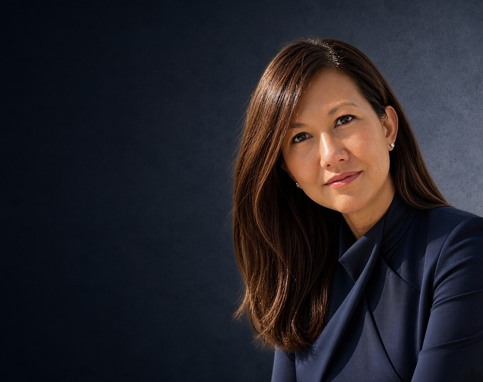 Executive coach Nga Janosov wearing a navy blue dress, standing confidently against a dark textured background.