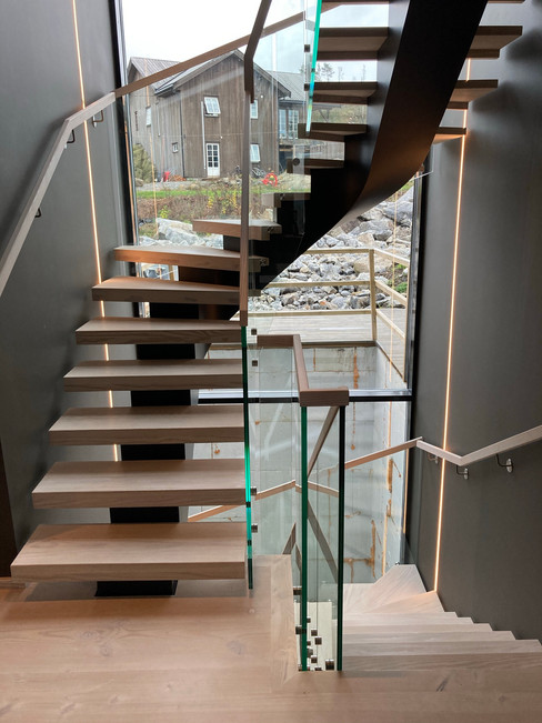 3-floor staircase with black steel construction and glass railings.