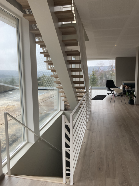 Straight staircase from oak with white-painted steel construction matching the railings.