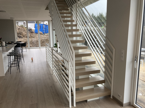 Straight staircase from oak with white-painted steel construction matching the railings.