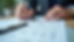 Close-up view of a person reviewing printed tax forms with a pen