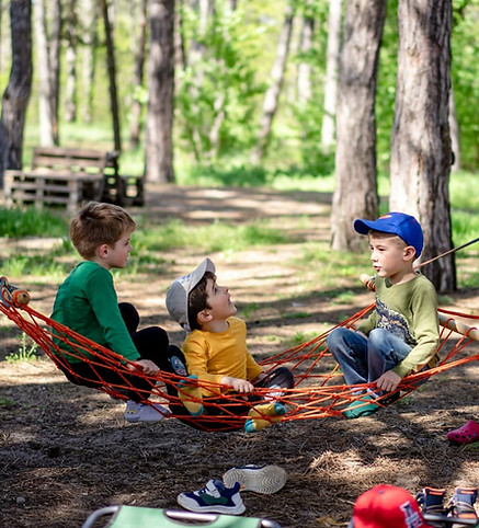 Naturnahes Lernen und unbeschwerte Kindheit – spielende Kinder auf einer Hängematte als Sinnbild für das pädagogische Konzept in Alma Hills.
