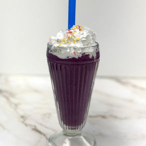 parfait cup with purple blueberry raspberry grimace shake topping with coconut whipcream and fun coloured sprinkles