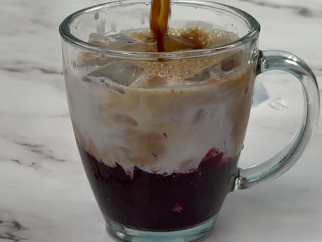 clear glass mug with blueberry latte
