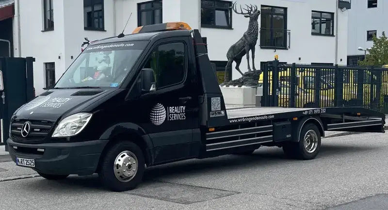 Abschleppfahrzeug von Reality Services für Auto Pannenhilfe in München, bereit für schnellen und zuverlässigen Abschleppdienst vor modernen Gebäuden.