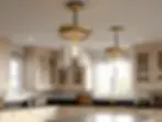 Close-up of modern gold and glass pendant lights hanging over a kitchen island, with cream cabinetry and black countertops in the background.