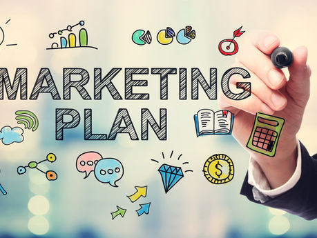 Business hand drawing MARKETING PLAN with colorful strategy doodles, charts, money, and icons on a blurred office background.