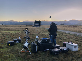 Drone crew setting up camera drone on remote film location in Queenstown
