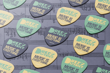 Guitar picks on sheet music background.