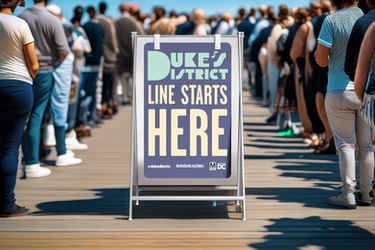 Sign reading "Duke's District Line Starts Here" on boardwalk.