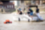 Vier Menschen auf einem Sportboot retten eine Person die im Wasser treibt