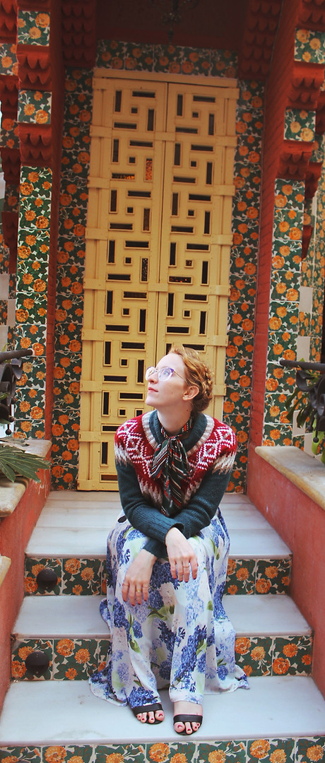 A woman in a floral dress sitting on a set of stairs in Barcelona