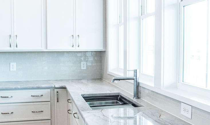 Granite kitchen countertops with painted cabinetry and polished nickel fixtures.
