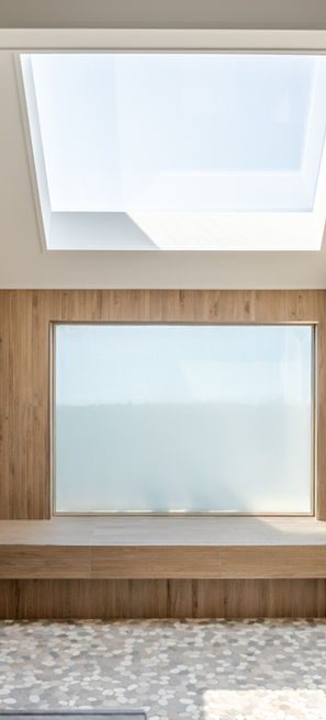 Large shower with wood-look tile, pebble shower floors, and panoramic ocean views in a beachfront home in Pine Knoll Shores, Carteret County, NC.