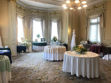 豪華な会場に複数のテーブルが並び、花々が飾られたイベント風景。