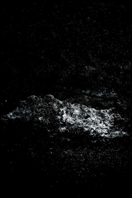 A quiet, fragmented presence with archaic surfaces blurs boundaries between tangible and ephemeral space.