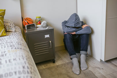 Young man sitting on the floor in his room