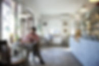 A man sitting at a table in an otherwise empty coffee shop
