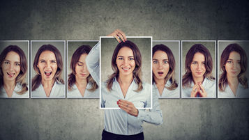 A woman surrounded by photos of herself expressing different emotions