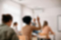 A woman raising her hand in a classroom