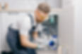 Plumber working install new cartridge for cold water filter in white kitchen_edited.jpg