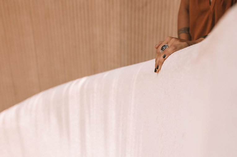 Hand touching curved plaster wall detail in custom residential design-build project