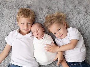 אחים עם תינוק בצילומי ניובורן ומשפחה