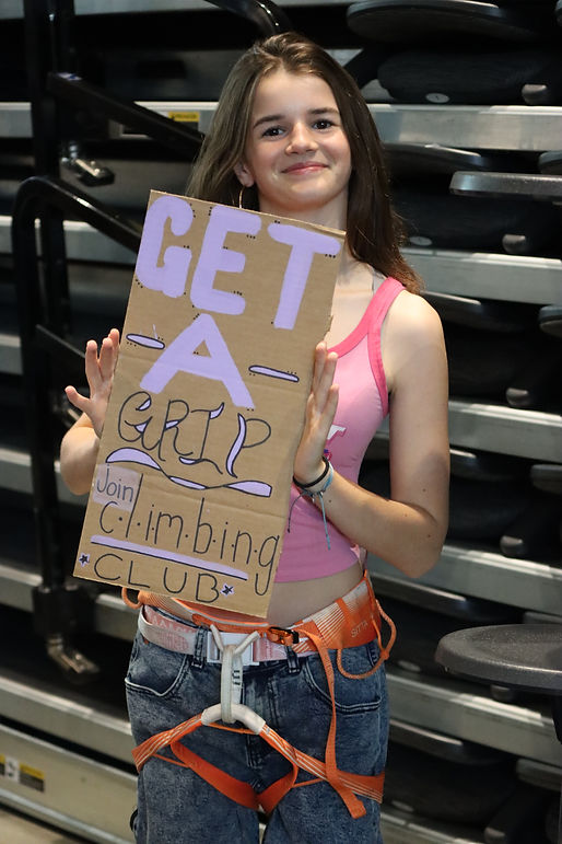 Allison Ward (11) poses with her sign during Club Rush to promote the Rock Climbing club and get people to sign up. Photo credit: Audrey Slatta (12)