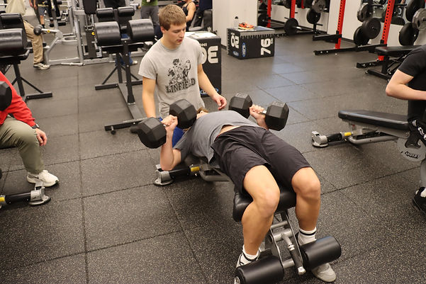 CHS students start their morning strong with a pre-class workout in the new Nutrition and Wellness course. Gene Witt (11) and Jackson Young (11) help each other during the morning routine before heading off to make a nutritious breakfast. Photo credit: Parker Hollatz (12).
