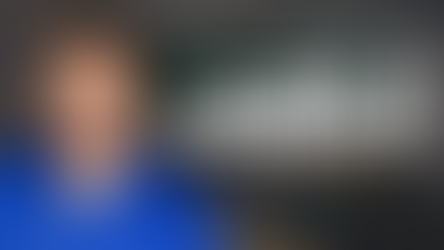 Desmund Ullrich in blue shirt in a classroom. Text: "Preparing Future School Leaders for Ethical AI Governance." Classroom desks visible.