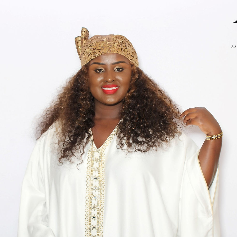 Lydia Nimbeshaho, founder of Tranquil Minds Psychotherapy, smiles in traditional attire, welcoming visitors and reflecting the warm, inclusive spirit of the practice.