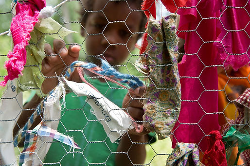 boy strings fabric on chicken wire