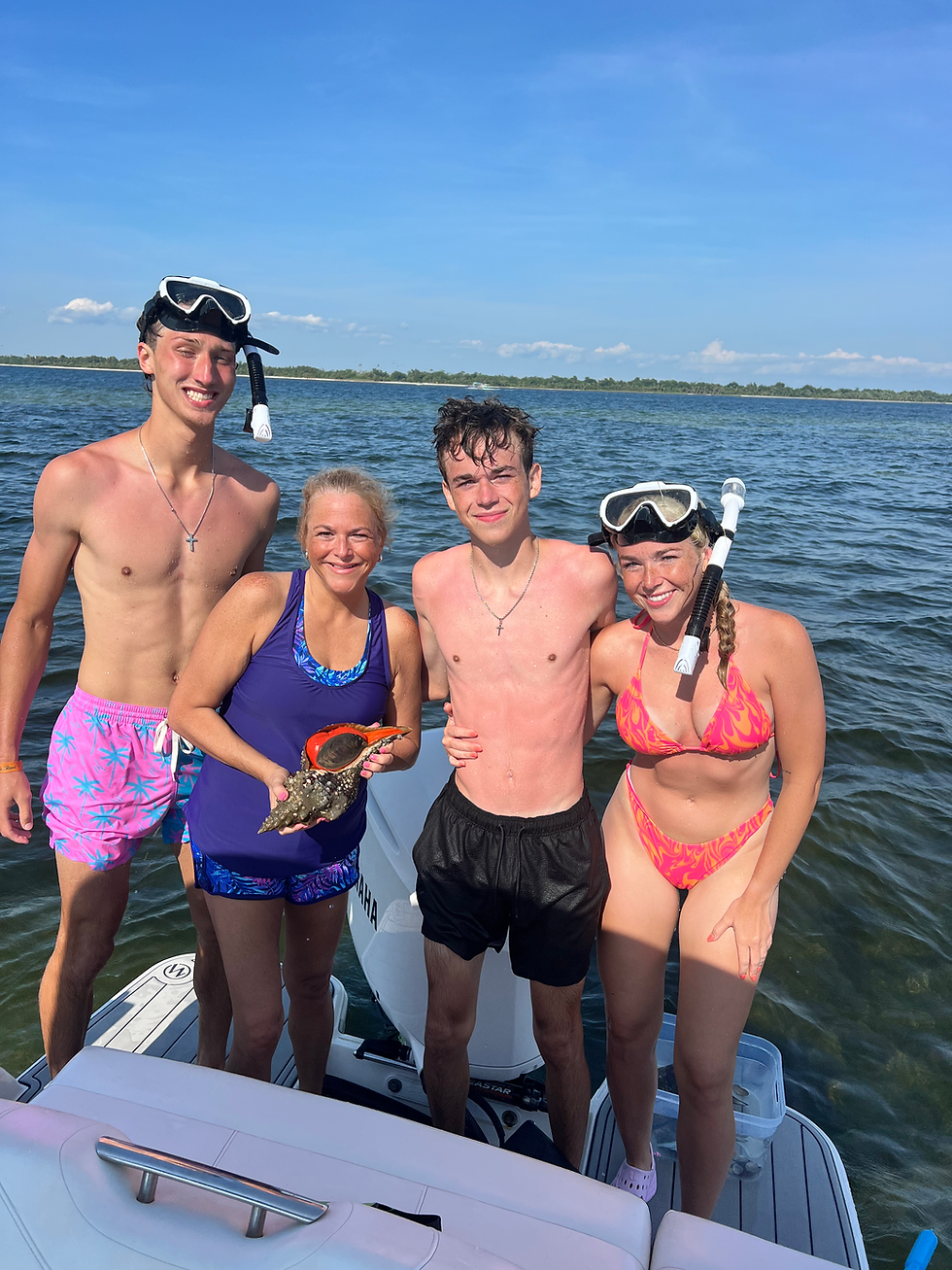 Four people on a boat with a Panama City Beach Marine Life Guide.