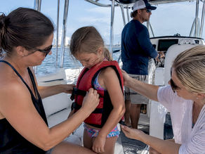 Family securing life jacket before boat tour