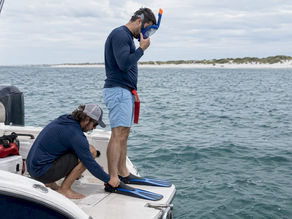 Guest being fitted with snorkel gear on boat