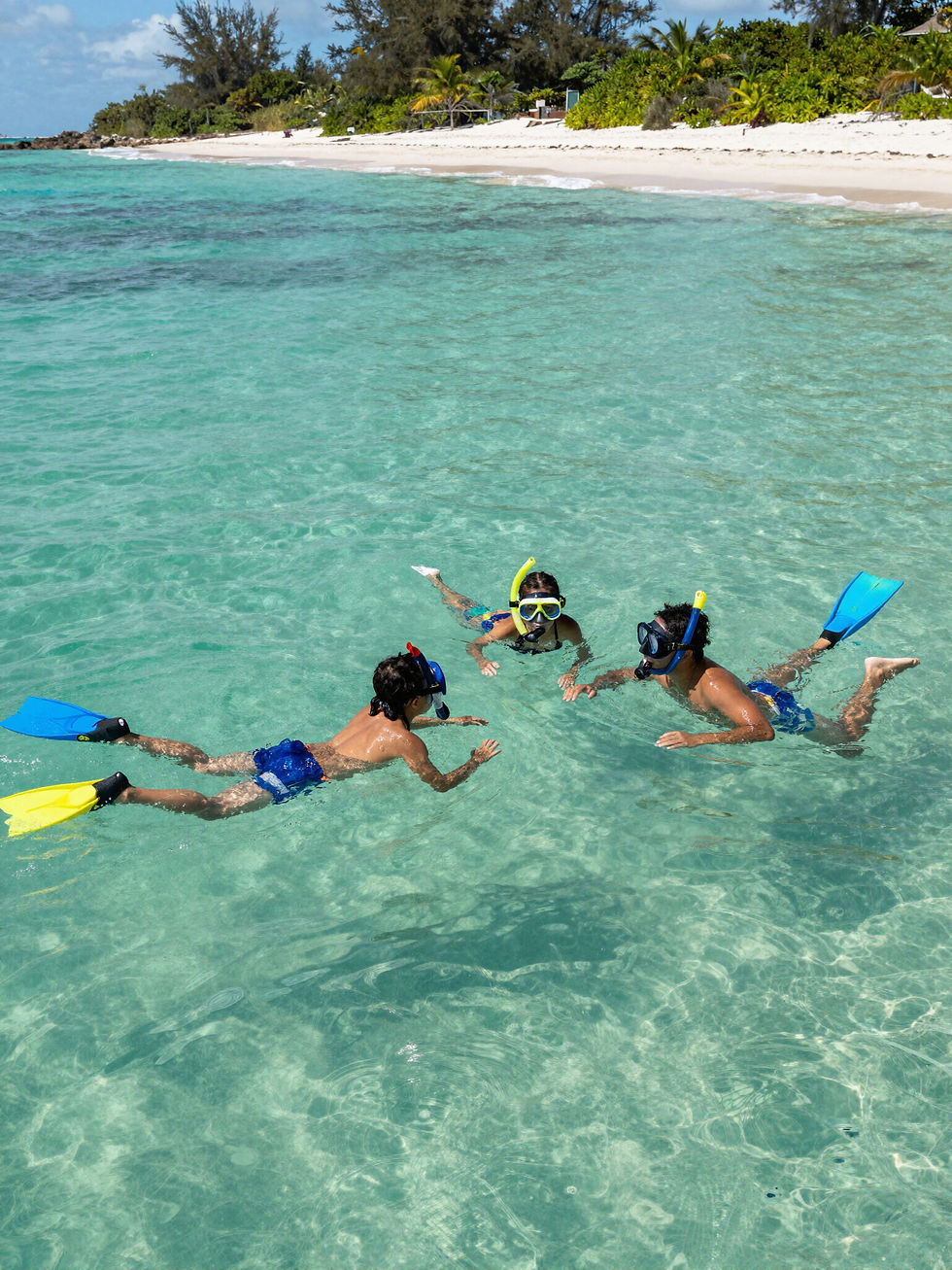 Smiling girls in goggles holding a starfish in clear ocean