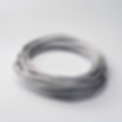 roll of galvanized wire rope on the floor, white in color on a white background