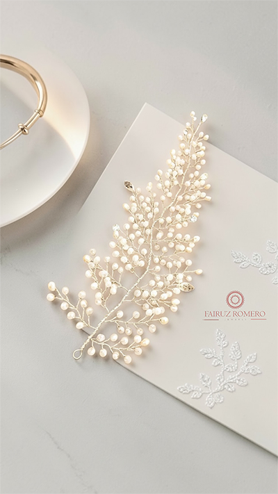 Tocado artesanal de Fairuz Romero Jewelry inspirado en la naturaleza, con delicadas ramas, hojas, y detalles de cristal para complementar el peinado de novia.