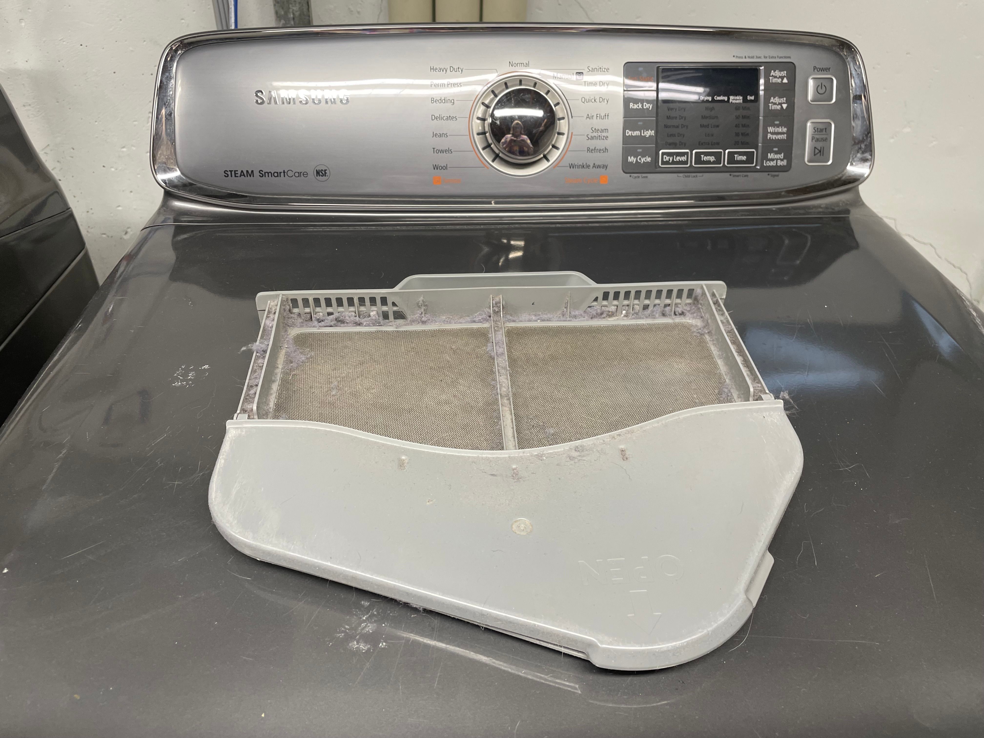 Photo of a dryer lint trap sitting on top of a dryer.