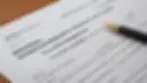 Eye-level view of a rental registration document with pen