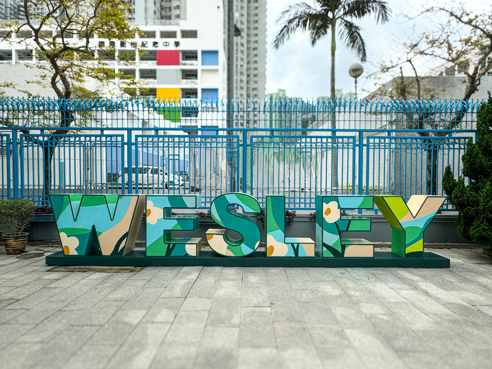戶外廣場藍色鐵欄杆前 WESLEY 立體英文字體裝置的外牆彩繪壁畫工程