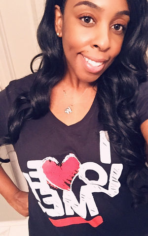 Shelle, the designer behind Moore Inspiration, smiling in a black heart T-shirt