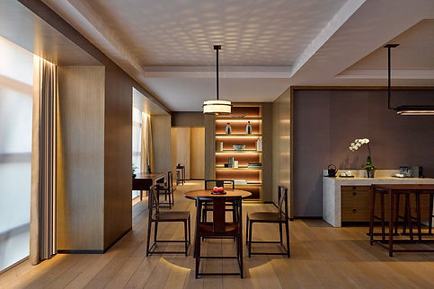 Hotel suite with table and 4 chairs, display of books and artifacts