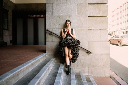 Woman on outside stairs drinking a can of soda Angela Haig Dunedin Photographer