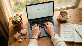Eine entspannte Ansicht von oben auf einen Schreibtisch mit Laptop, Tee, Notizbuch und Rosenquarz im warmen Morgenlicht, an dem eine Frau mit Leichtigkeit ihren Blogpost schreiben wird.